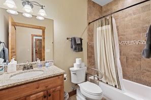 A bathroom with two sinks, a toilet, and a shower area. - The Pines 3 Bedroom Condo (Whitefish)