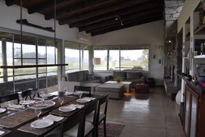 Relax in this inviting living area with a high ceiling, dining table, and comfortable seating.