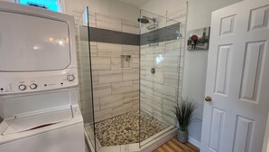 A walk-in shower with glass doors, a white door, and a potted plant. - 1 Bedroom Studio located near Isle of Palms and downtown Charleston! (Mt Pleasant)