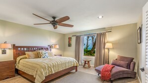 A bedroom with a bed, a ceiling fan, a nightstand, a chair, and a window with curtains. - Eastside Zen Retreat, Pono Kai
4/25-5/3 - Discounted 15% (Kapa'a)