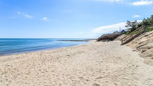 A sandy beach with a wooden staircase leading down to the water. - Ocean Front, Private Beach, Ocean View , Private patio (Dennis)