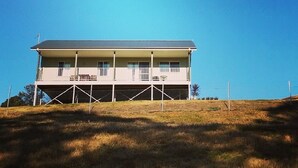 A two-story building with a flat roof and a balcony on the second floor. - Highfields Country group Cottage  2 Bedroom (Kurrajong)