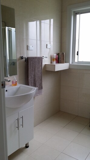 Regadera, secadora de cabello, toallas, papel de baño 
