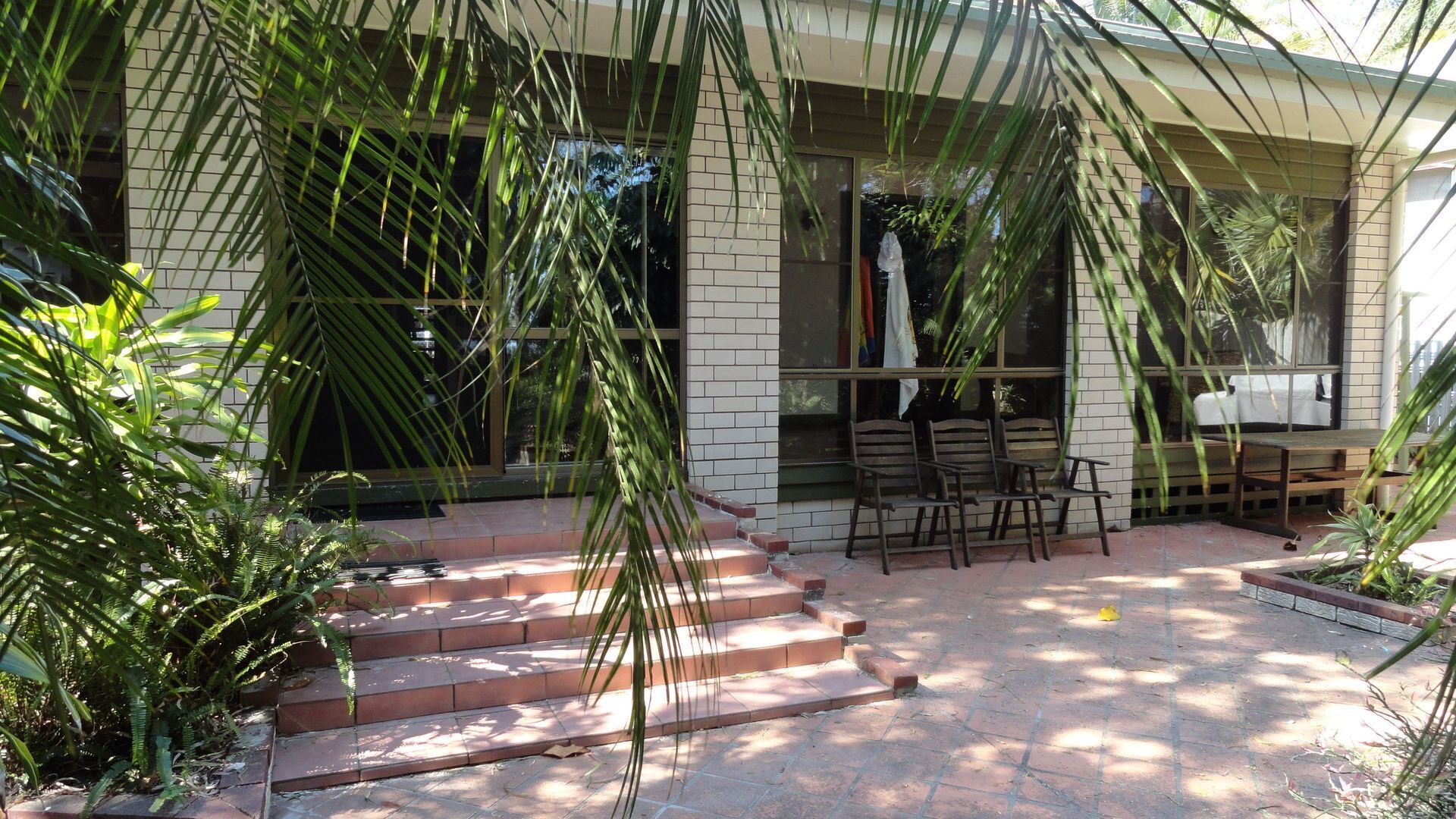 Fenced backyard with outdoor setting and BBQ.