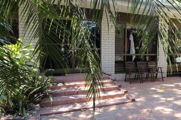 Fenced backyard with outdoor setting and BBQ.