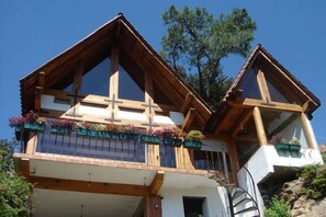 A chalet-style building with a steeply pitched roof, wooden beams, and a balcony with flower boxes. - Chalet los Cuatro Manguitos for 10 people 5 min away from lake & downtown (Valle de Bravo)