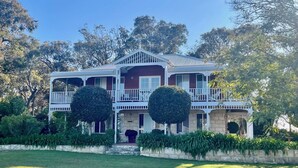 A two-story house with a balcony, surrounded by greenery and trees. - MILLHAVEN - beautiful home in superb location with ocean views. (Quedjinup)