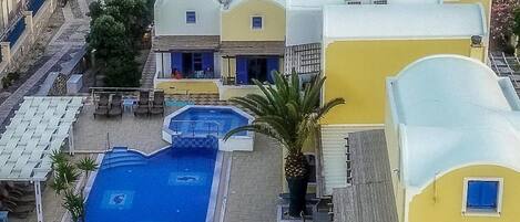 A resort with multiple swimming pools, a beach view, and a variety of building styles.