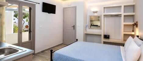 Una camera da letto con un letto, un armadio a muro, una televisione e una finestra vista verde.