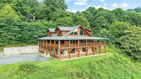 A log cabin with a balcony and a stone wall.