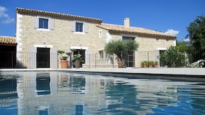Un edificio in pietra con una piscina di fronte.