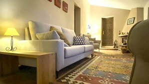 A living room with a sofa, a patterned rug, a wooden coffee table, and a ceiling fan. - Luxurious 'finca' With Private Pool In The 'campo' (Cómpeta)