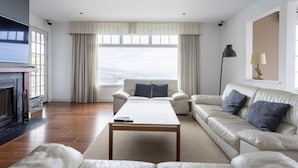 A modern living room with a sofa, a coffee table, and a TV. - Villa With  Best Amazing Ocean Views (Santa Úrsula)
