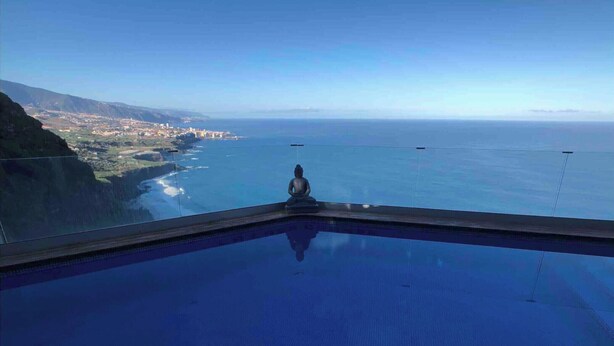 A clear view of a swimming pool with a Buddha statue in the center, overlooking a coastal landscape. - Villa With  Best Amazing Ocean Views (Santa Úrsula)