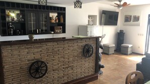 Een keuken met een bakstenen muur, twee zwarte wielen, een hanglamp en een plafondventilator.