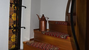 A wooden staircase with patterned carpeted steps, a wrought iron gate, and a potted plant on the landing. - Suite with terrace and view of the church, lake access - Ferienhof Löschebrand (Bad Saarow)