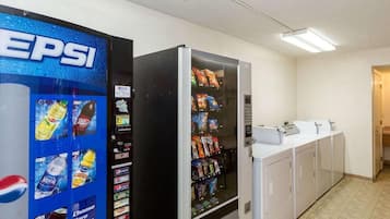 A vending machine with Pepsi and Dr. Pepper options, a microwave, and a sink in a public area.