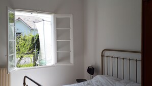 Une chambre à coucher avec un lit, une fenêtre et un luminaire suspendu.