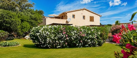 Ein zweistöckiges Haus mit einem Garten davor.