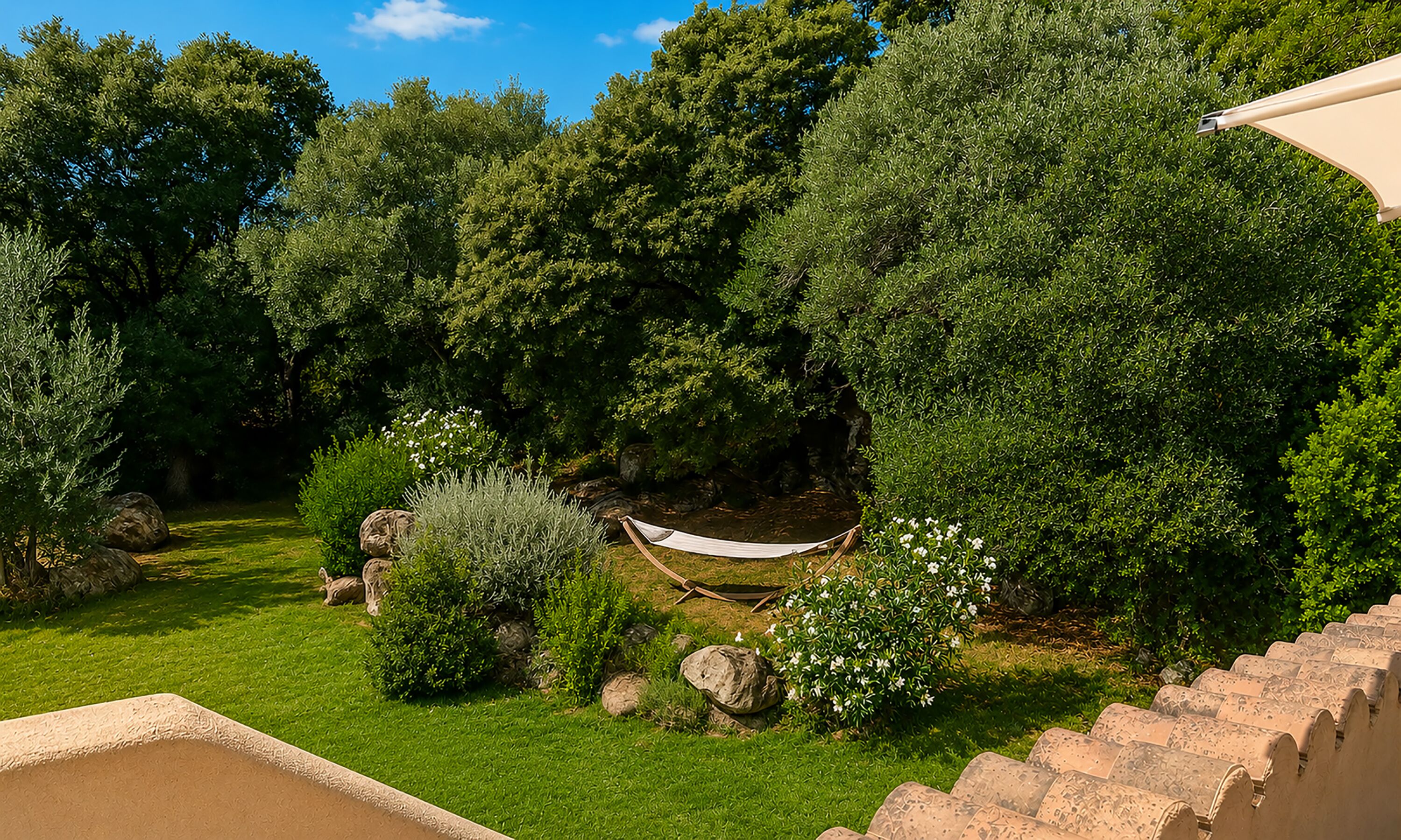 A garden with a hammock, rocks, and various trees.