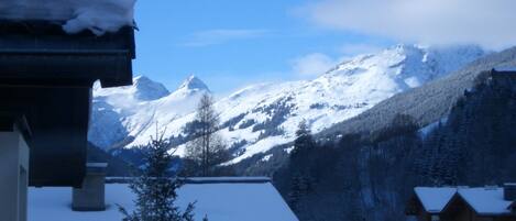 A snow-covered mountain landscape with a chalet-style building in the foreground.