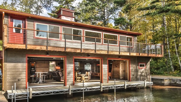 Une maison flottante dotée d’une terrasse, d’un espace salon extérieur et d’un quai.