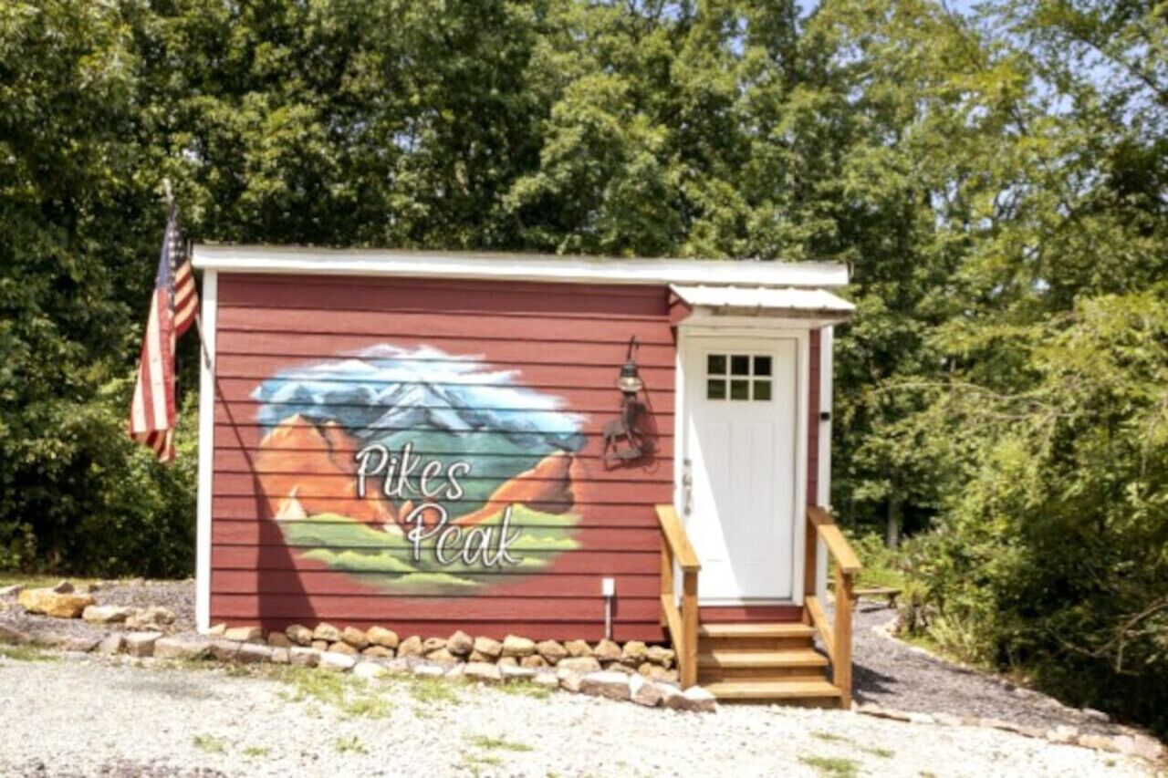 Une petite cabane ornée d’une fresque représentant une montagne, et sur laquelle on peut lire l’inscription « Pikes Peak ».