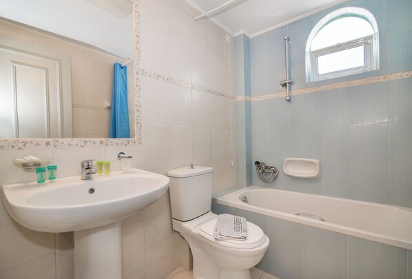 A bathroom with a sink, toilet, and bathtub.