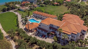 An aerial view of a coastal hotel with a swimming pool, multiple buildings, and a view of the sea. - Windmill Hotel (Zakynthos)