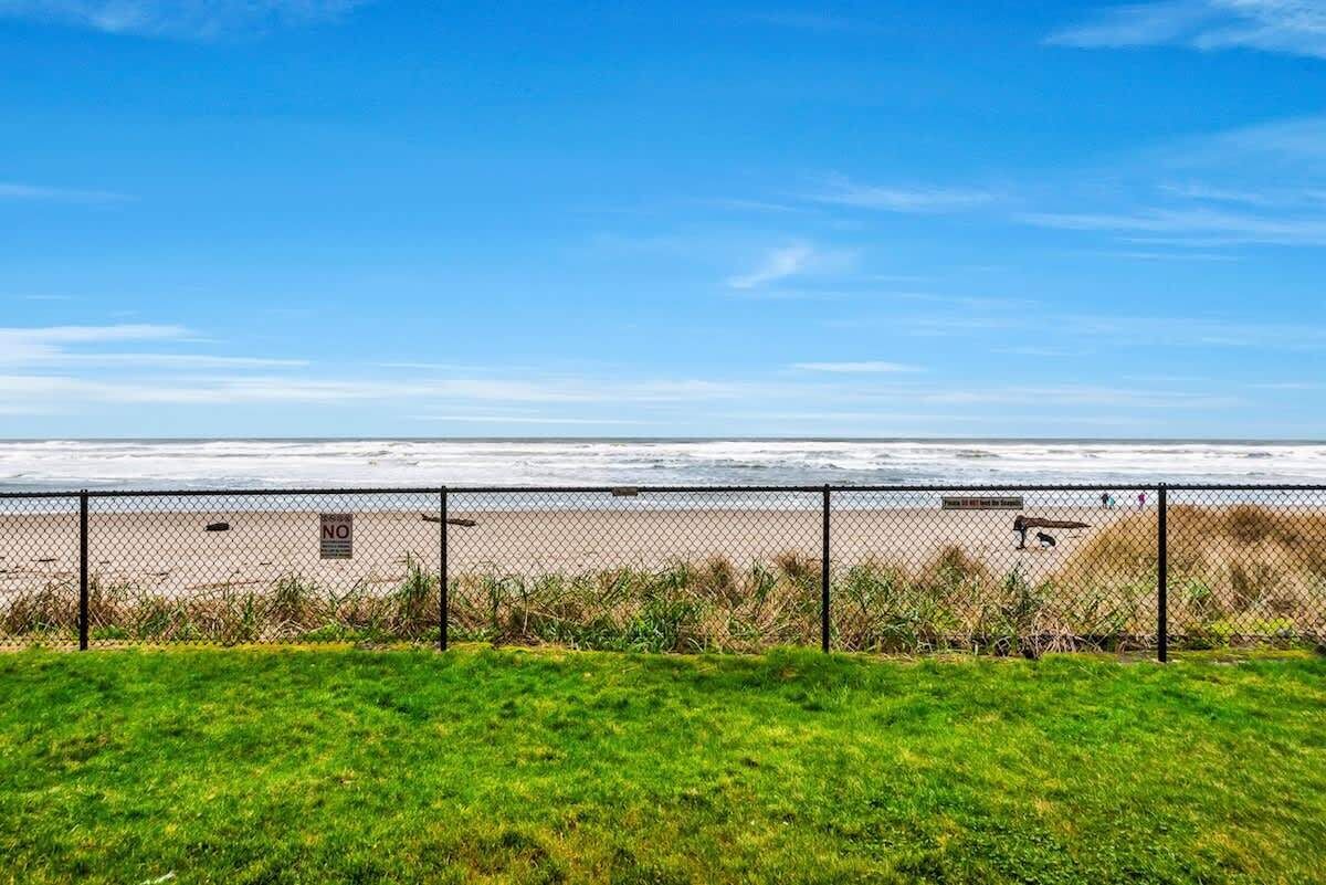 A fenced beach area with a clear view of the ocean.