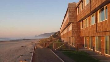A coastal building with a long, straight pathway leading to the beach.