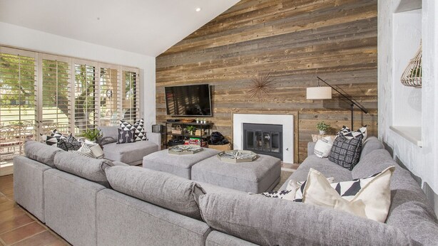 A modern living room with a fireplace, grey sofas, and a TV. - Relax in the Best and Biggest Space in Palm Valley Country Club. (Palm Desert)