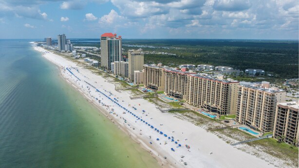 Ein Küstenort mit Hotels direkt am Strand, einem Sandstrand und freiem Blick auf den Ozean.