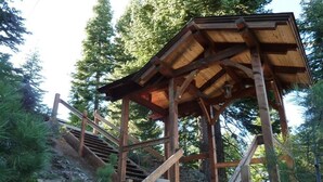 A wooden staircase leading to a covered wooden structure surrounded by trees. - Large Home, Lovely Lake Views, Great Getaway (Tahoma)