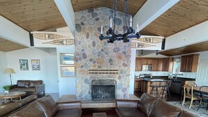 A spacious living room with a stone fireplace, leather sofas, and a herringbone-patterned coffee table. - Large Home, Lovely Lake Views, Great Getaway (Tahoma)
