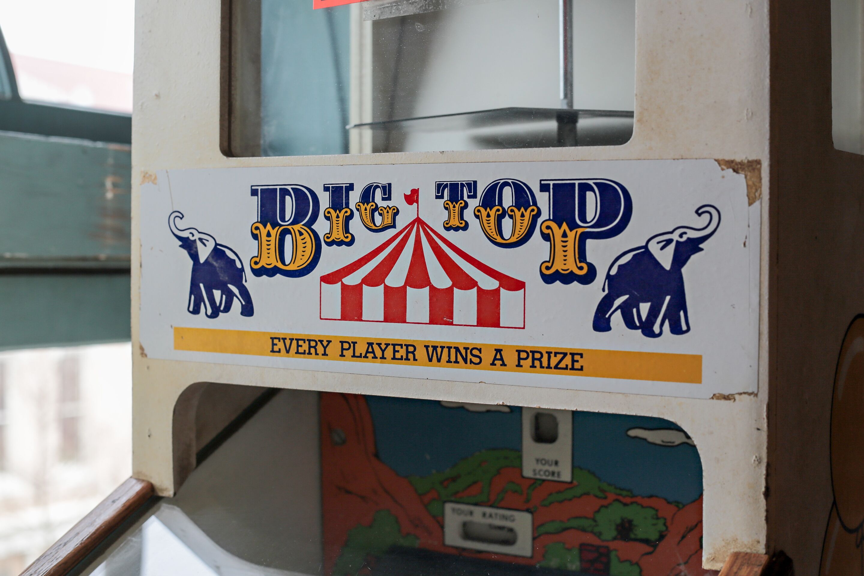 A game machine with a sign that reads 'BIG TOY LOTTO' and 'EVERY PLAYER WINS A PRIZE'.