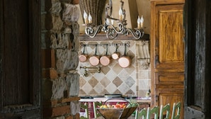 Una cocina rústica con paredes de ladrillo visto, una puerta de madera y salpicadero de azulejos.