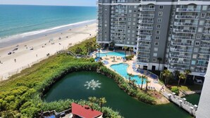 A hotel with a pool, beach, and ocean view.
