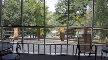 Enjoy a serene view of the wooded park from this outdoor seating area, featuring a space with two tables and four chairs.