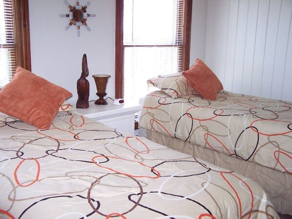 Un dormitorio con dos camas, un reloj de pared y un adorno decorativo.