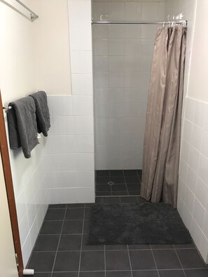 Een douche, handdoeken, zeep, shampoo