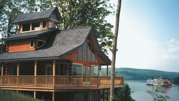A multi-story wooden cabin with a balcony overlooking a lake and a boat in the distance. - Exceptional views of the Ohio River and accommodates 2 boats (Magnet)