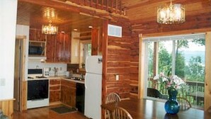 A wooden interior with a kitchen, dining area, and large windows. - Exceptional views of the Ohio River and accommodates 2 boats (Magnet)