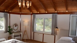 Une chambre avec deux lits, un bureau, une chaise, une lampe et une plante en pot.