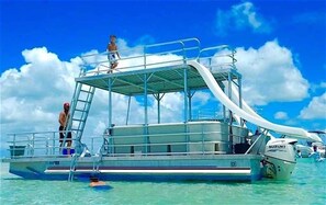 A boat with a ladder, a person on the deck, and another person on a platform. - Beach Townhouse w/ Private Pool - Steps from the Beach (Panama City)