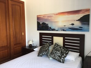 Relax in comfort with a large bed, framed coastal view, and convenient storage.