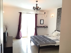 A bedroom with a bed, a chandelier, a wall-mounted air conditioner, and a window with curtains. - Villa Marko is Luxury 5 bedrooms apartment with private swimming pool (Baošici BB)