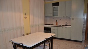 Cocina compacta con una mesa de comedor, sillas, un lavamanos y armarios.