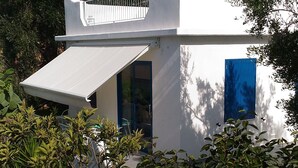 A modern white building with a blue door, surrounded by greenery. - CASA VACANZE A MATTINATA - GARGANO (Mattinata)