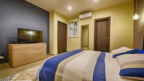 A bedroom with a bed, dresser, TV, and an air conditioning unit. - Three bedroom, luxury apartment with private pool (Ix-Xagħra)